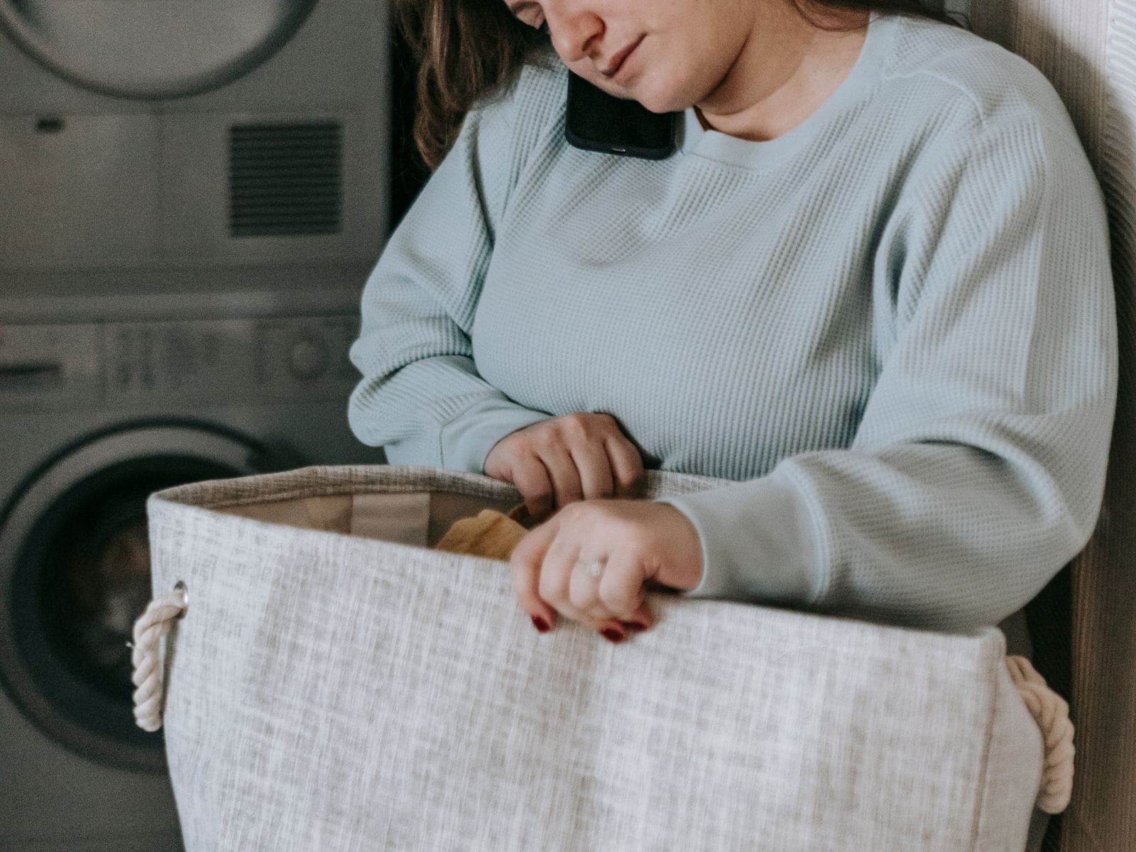 A customer arranging laundry in a WashMe-branded basket