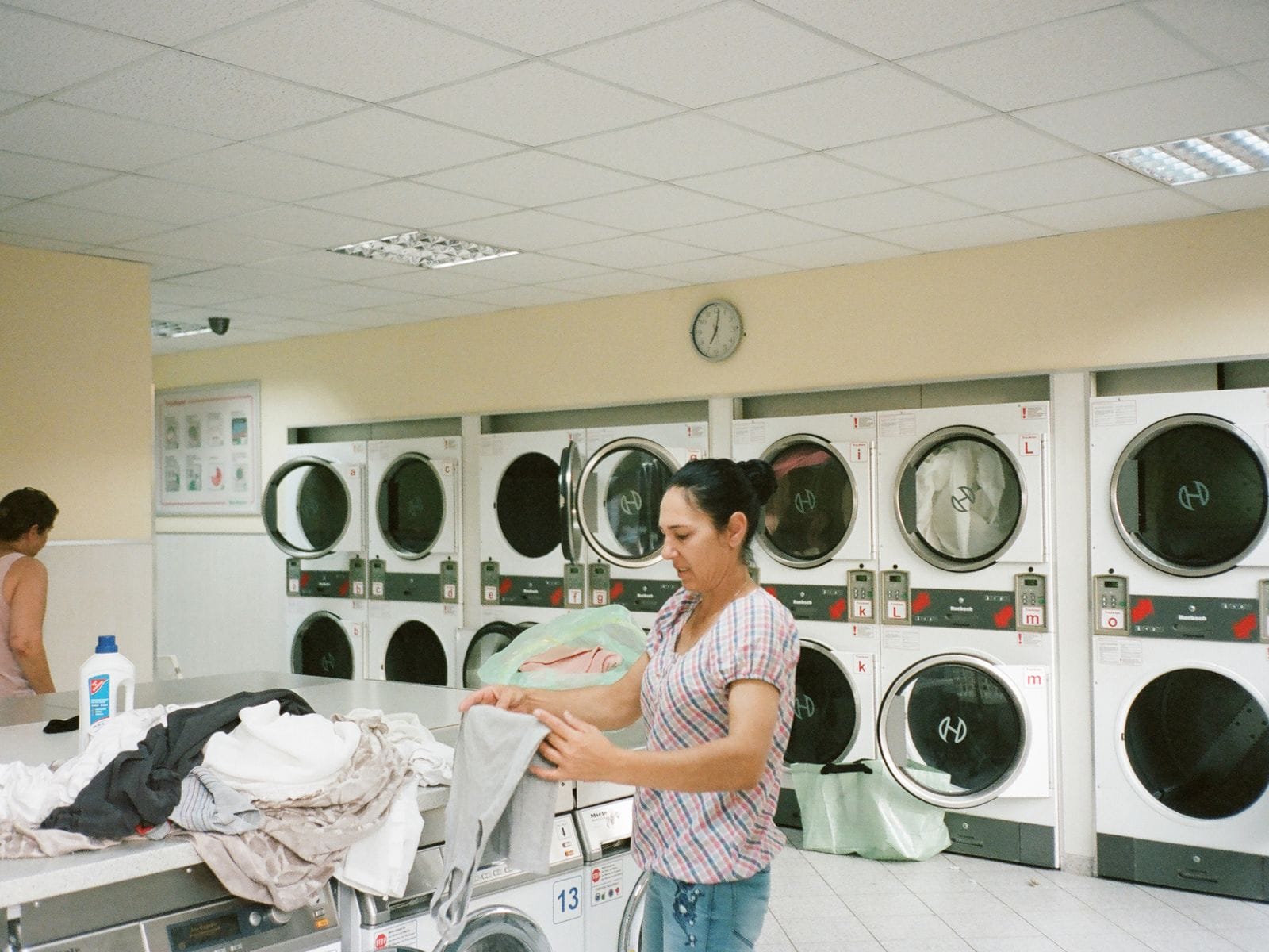 A WashMe laundry worker sorting an order beside washing machines